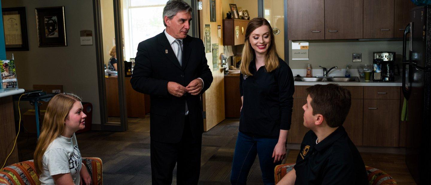 Honors college adviser and dean speaking to two students in an office